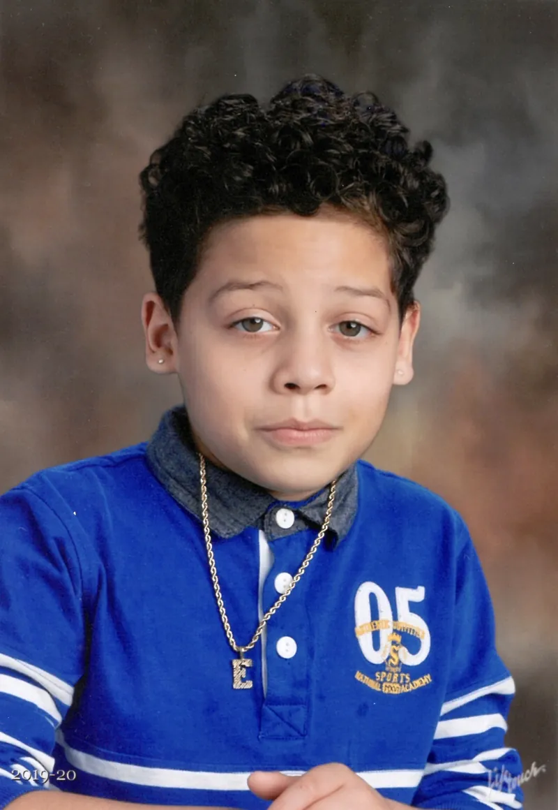 School portrait of one of the boys in a blue jersey